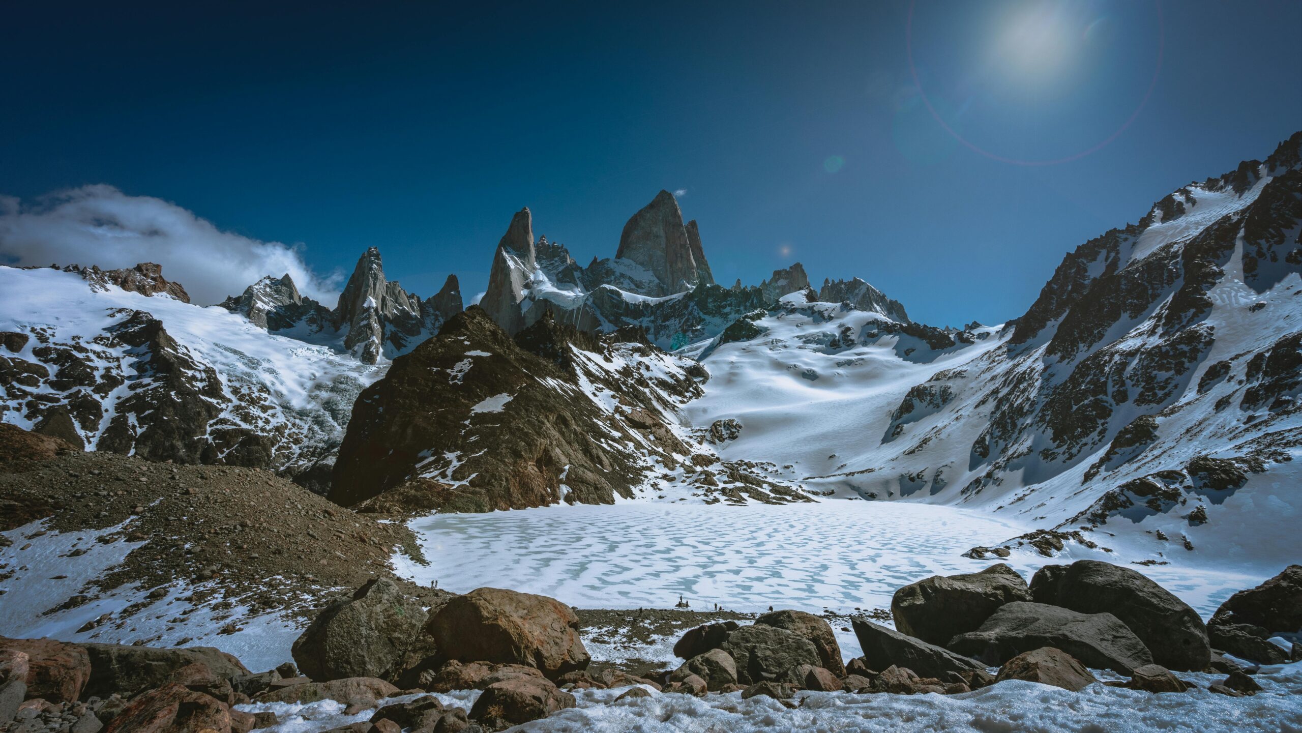 Majestic snow-covered mountains and rugged terrain in El Chaltén, Argentina under a clear winter sky.