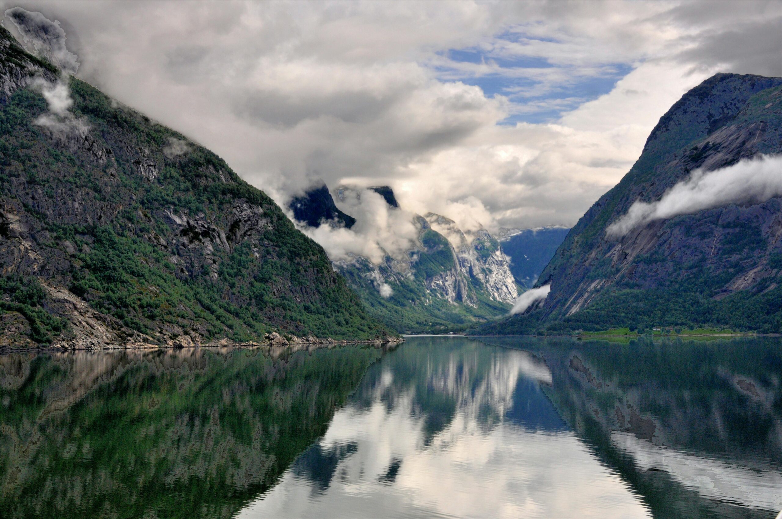 Breathtaking view of a Norwegian fjord with clear reflections and dramatic clouds.