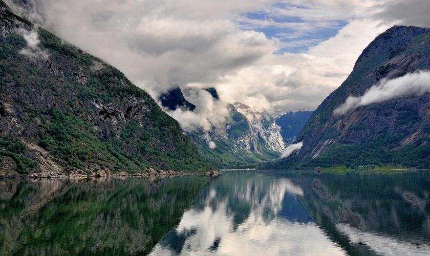 pexels-photo-631296-631296 Breathtaking view of a Norwegian fjord with clear reflections and dramatic clouds.